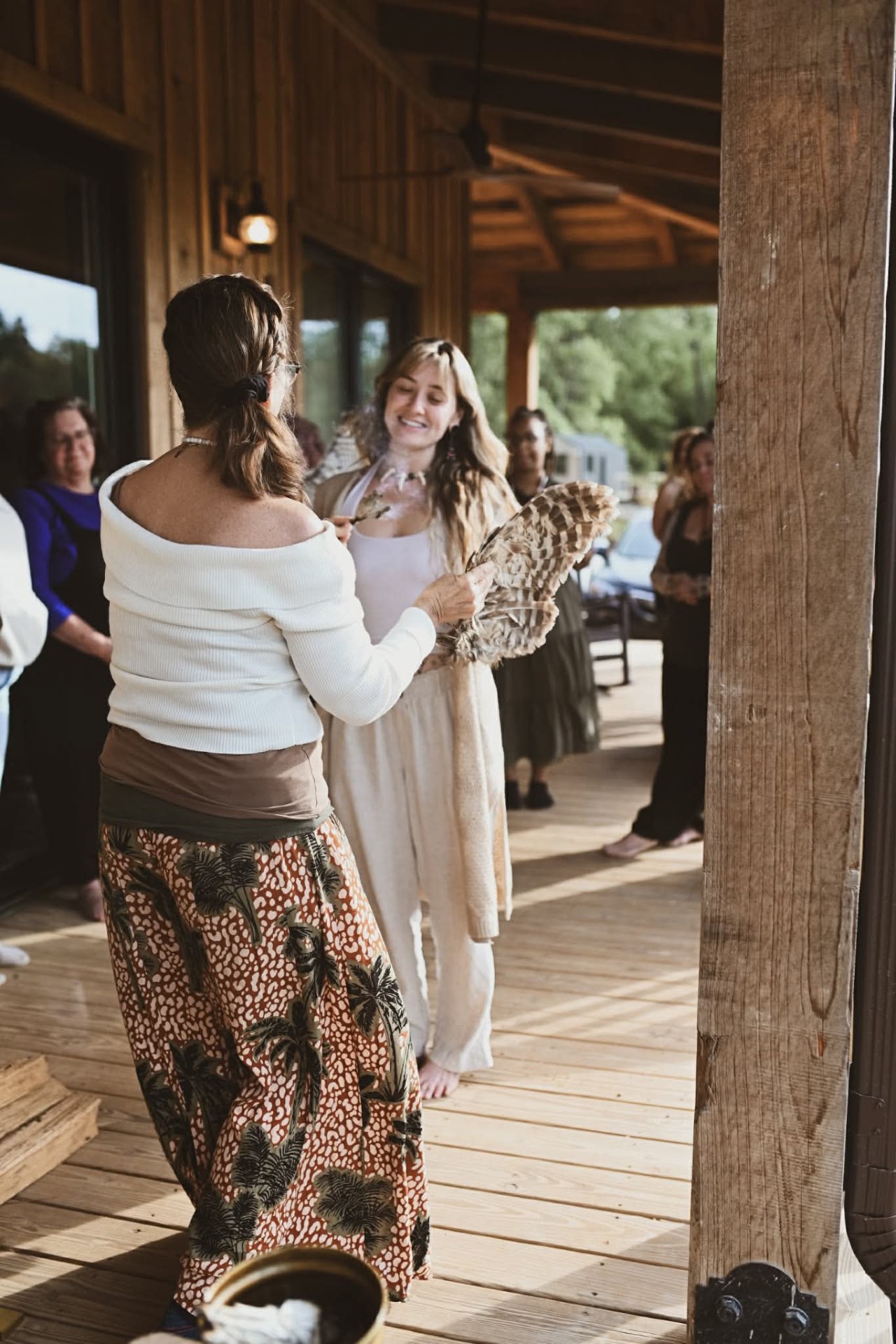 A woman holding a feather fan in ceremony