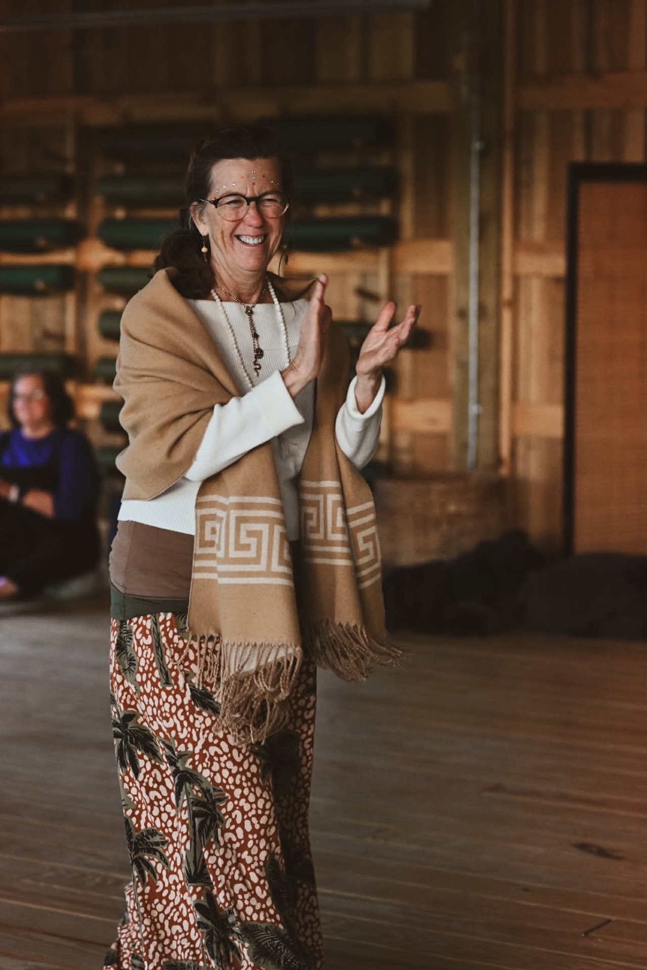 An elder sister laughing, draped in warm wool