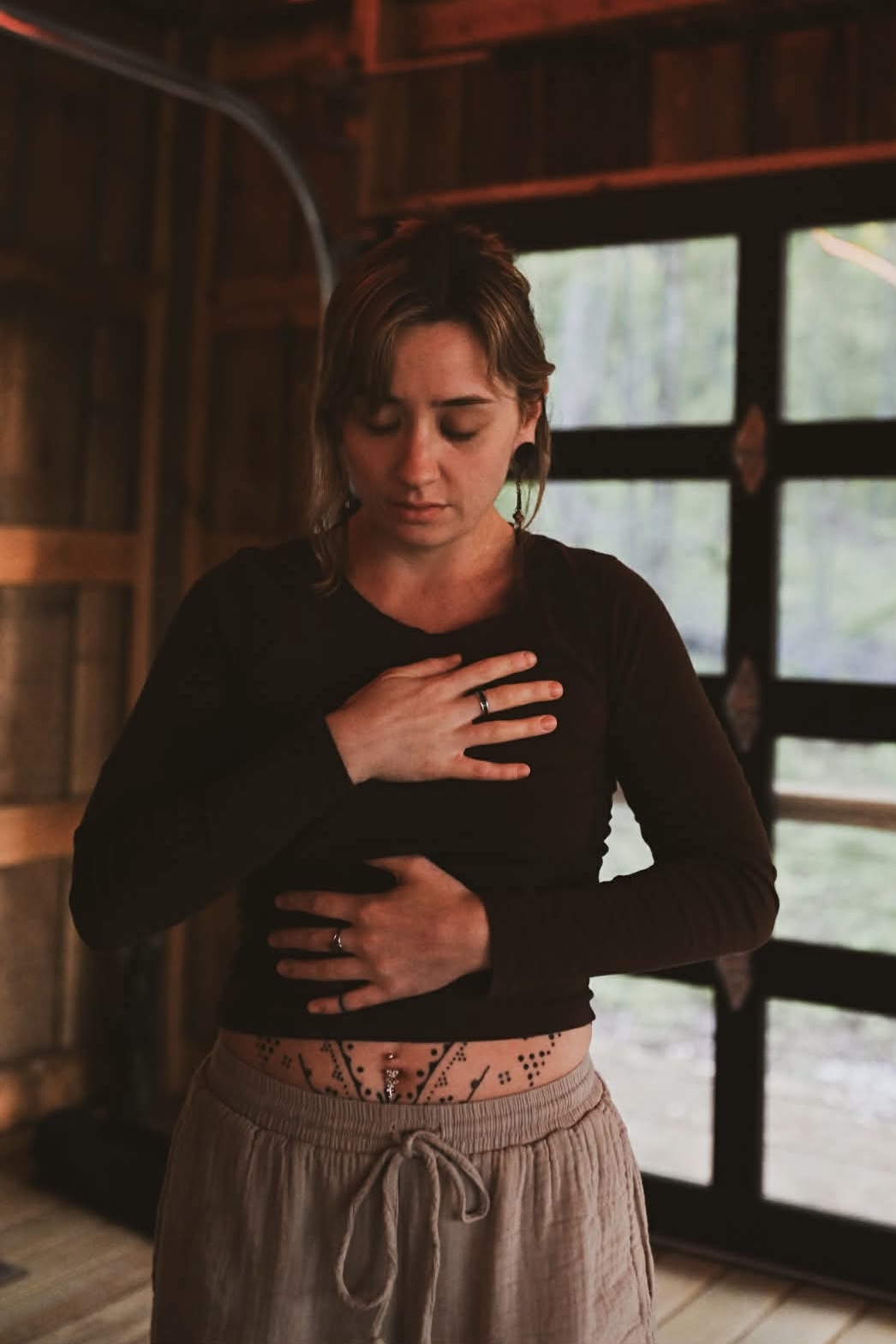 A woman breathing with hands resting over her heart